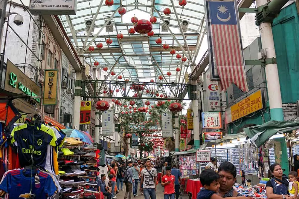 Shopping street with Chinese lanterns and lots of people walking around