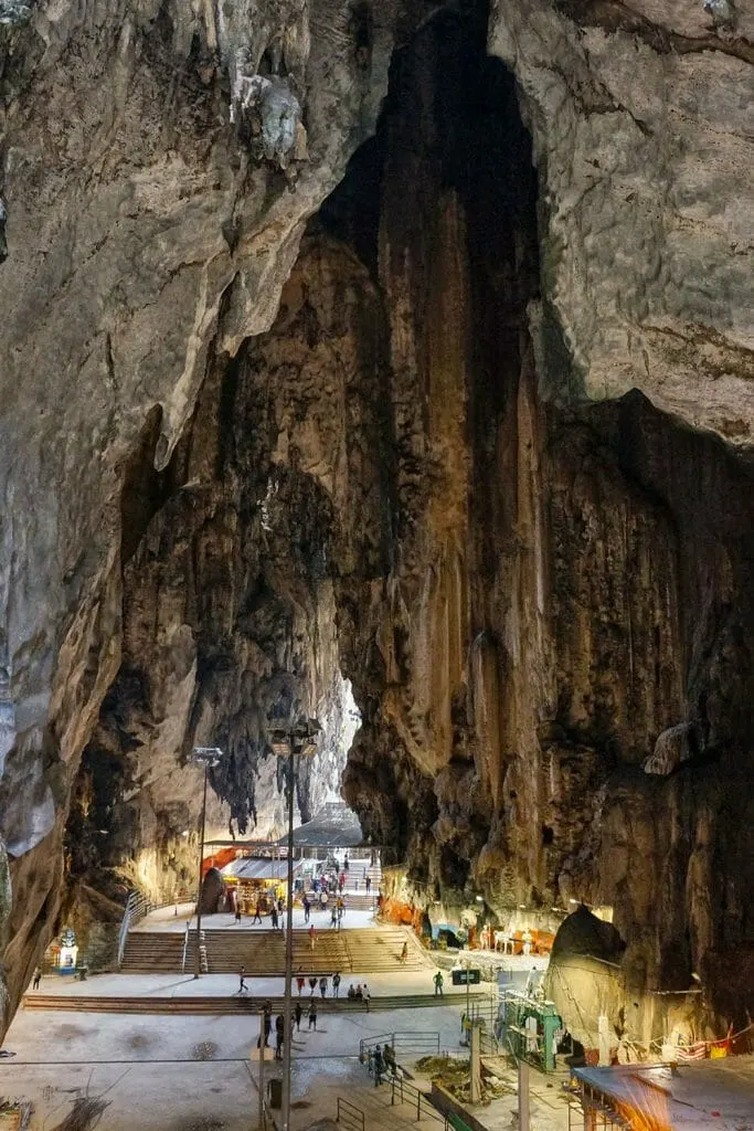 Steps and people walking inside an enormous cave