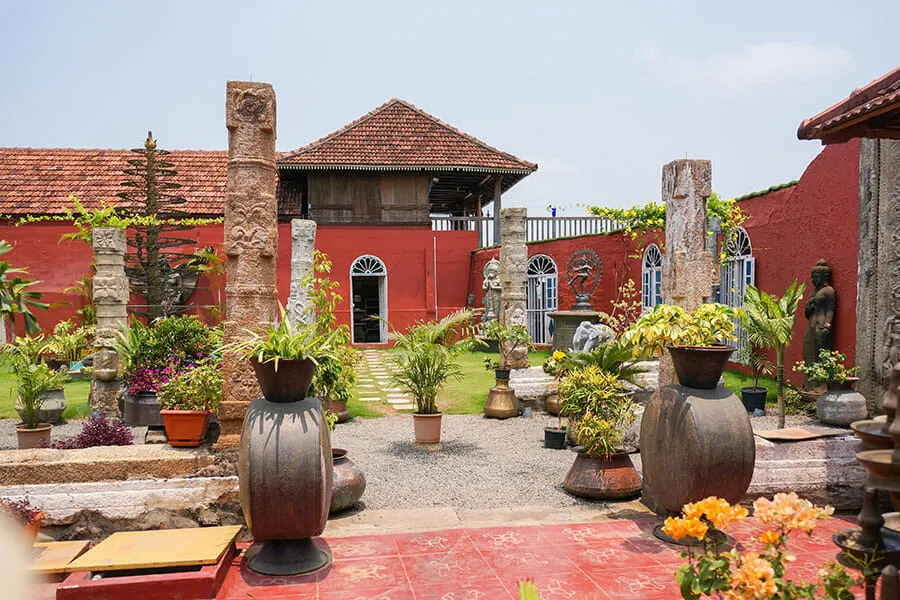 Courtyard with antiques and plant pots at Ginger House Cafe in Kochi