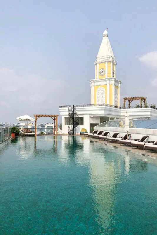 Swimming pool and clock tower on the rooftop terrace of the Fragrant Nature Kochi Hotel