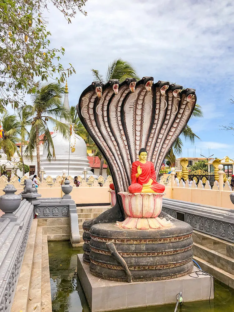 Statue of a seven head cobra over a sitting buddha