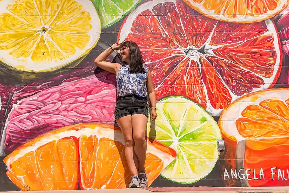 Standing in front of a wall mural of sliced citrus fruits in St Pete Florida