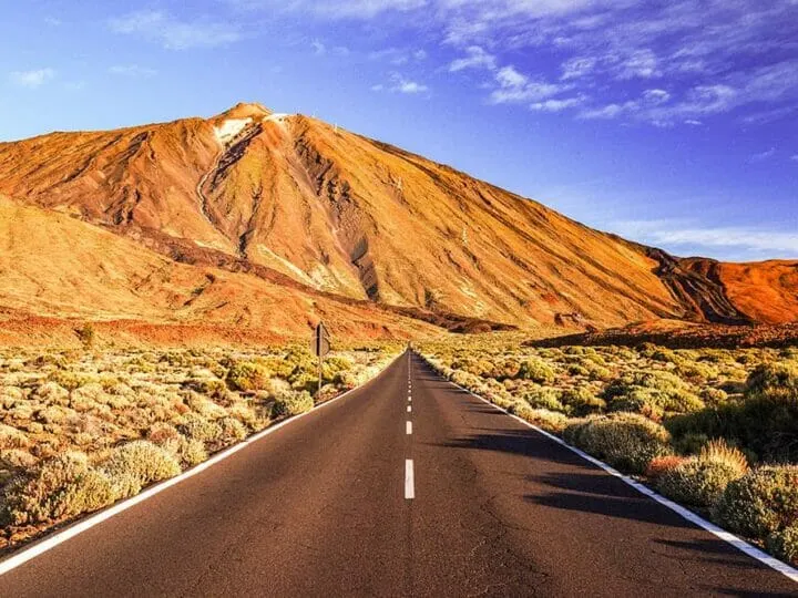 Road leading up to a volcano with an arid landscape around it, the perfect road for a road trip in Tenerife