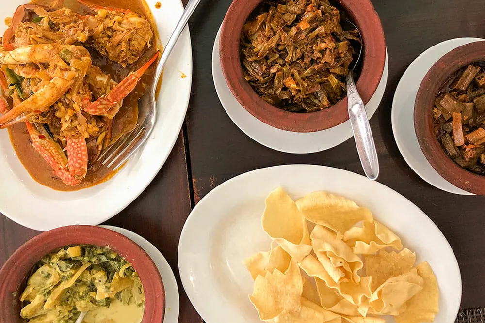 Selection of plates with curried crab clause, vegetables and and poppadoms