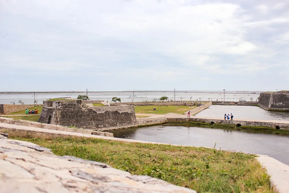 View over Jaffna Fort, moat and lagoon people walking around in the distance