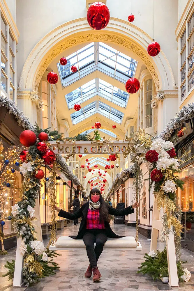 Me sitting in a large swing inside an arcade decorated with Christmas decorations