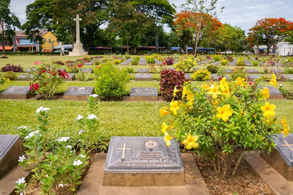 Rows of graves and flowers at the Allied Forces War Cemetery in Kanchanaburi, Thailand