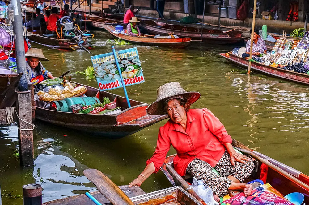 Vendor selling coconut pancakes at a Bangkok floating market, a favourite among the 10 best things to do in Thailand