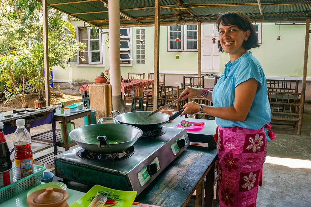 Cooking a Thai dish during a Chiang Mai cooking class, a favourite stop on this 10 day Thailand tour