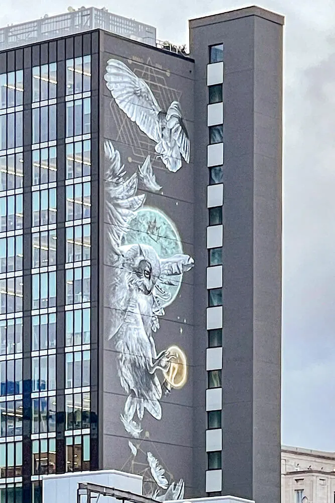 Tall modern building with a large mural of owls flying