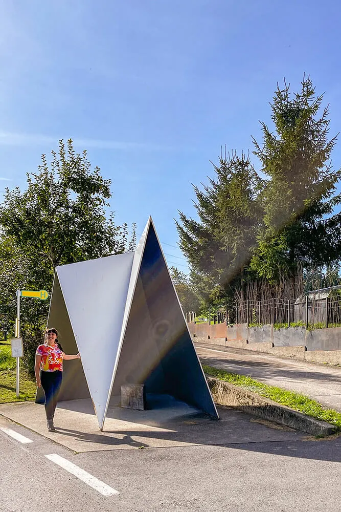 Me standing by a bus stop made to look like a metal mountain peak