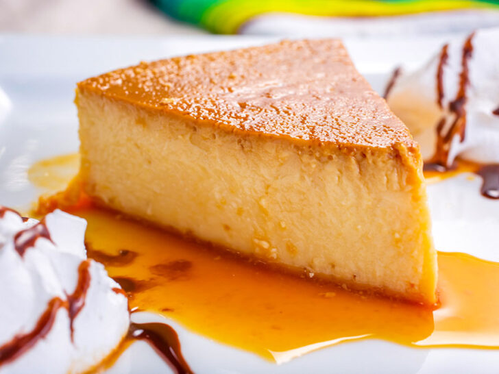 A caramel custard dessert served on a white plate with whip cream on both sides